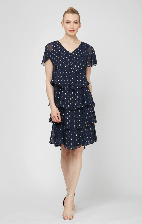 Woman wearing a navy blue dress with white patterns on a white background