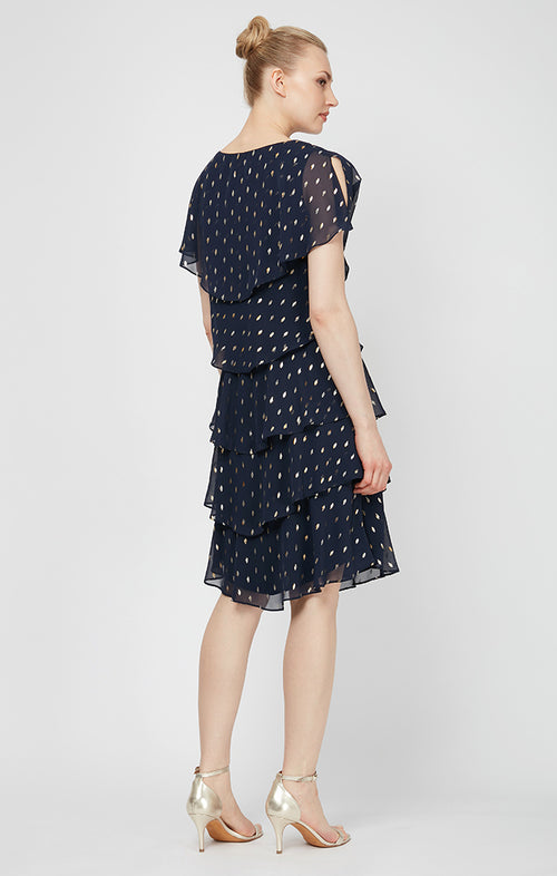 Woman wearing a navy blue dress with white polka dots on a white background